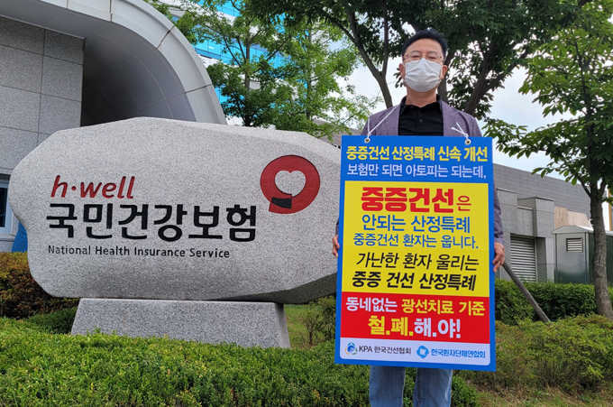 한국건선협회 선이나라 김성기 대표가 6일 원주 건보공단 앞에서 1인 시위에 나섰다.  